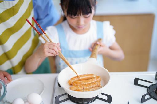 エプロン姿で調理をする人の上半身 女の子,ソーセージ,日本人の写真素材
