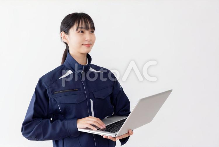 ノートパソコンを使う作業服の女性 女性,人物,日本人の写真素材