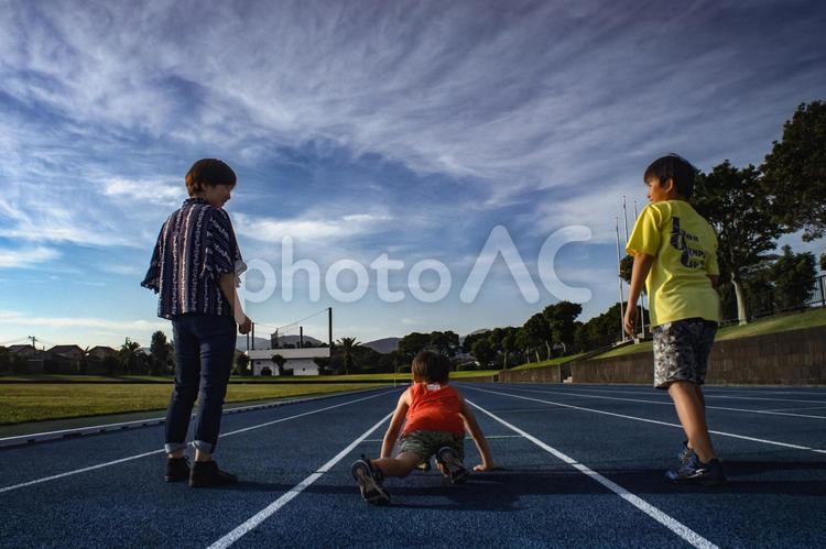 ＜素材＞夕暮れに家族で短距離走をする親子 家族,親子,女性の写真素材