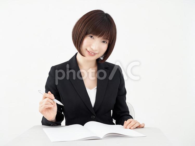白い背景でデスクでヒアリングをする女性OL 女性,ol,メモの写真素材