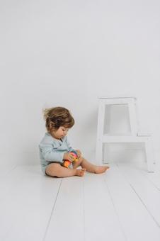 床に座り玩具に夢中な子供 床に座り玩具に夢中な子供 赤ちゃん,かわいい,玩具の写真素材