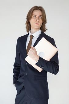 ノートパソコンを抱えるスーツの男性 男性,外国人,欧米人の写真素材