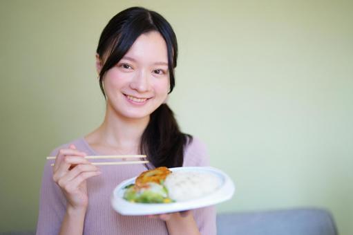 料理を持って嬉しそうに微笑む女性 女性,食事,食べ物の写真素材