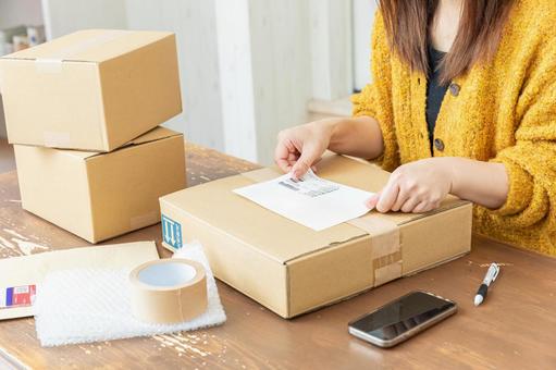 荷物の発送準備をする女性 配送,配達,段ボールの写真素材