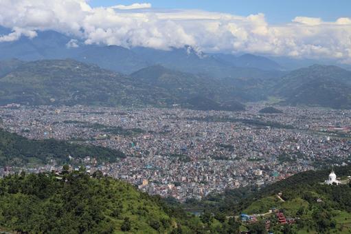 青空と雲と山並みとネパールポカラの街並みの写真