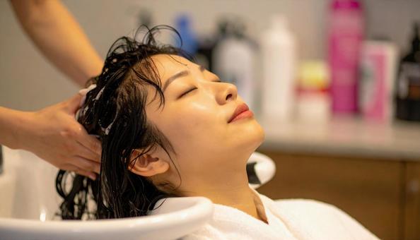美容室でシャンプーしてもらう女性 美容室でシャンプーしてもらう女性の写真