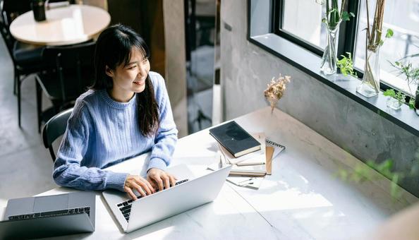 カフェで仕事をするフリーランス女性 カフェで仕事をするフリーランス女性の写真