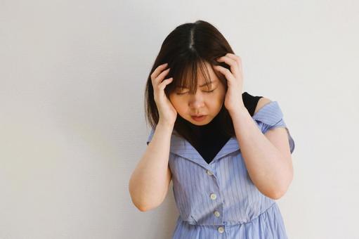 頭を抱える女性 頭を抱える女性の写真