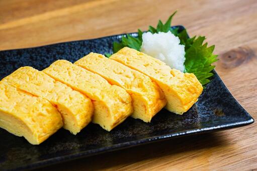 黒い皿に盛り付けただし巻き卵と大根おろし だし巻き玉子,卵料理,和食の写真素材