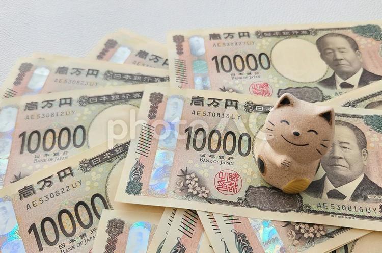お願いする招き猫と散らばった1万円札 お金,招き猫,幸運の写真素材