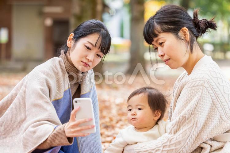 公園でママ友と話す女性（困る） ママ友,アプリ,スマホの写真素材