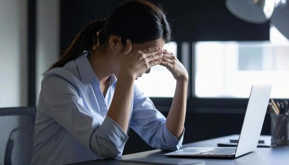 仕事で失敗して悩む女性社員 仕事で失敗して悩む女性社員の写真