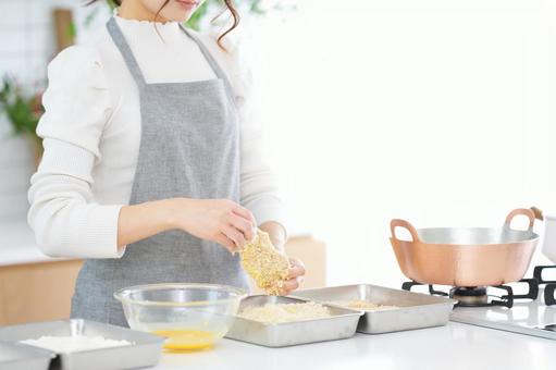 とんかつの衣づけをする女性の手 とんかつの衣づけをする女性の手の写真