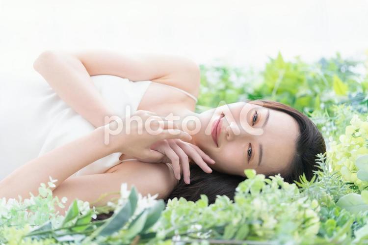 緑の中でスキンケアをする若い女性 ビューティー,女性,スキンケアの写真素材