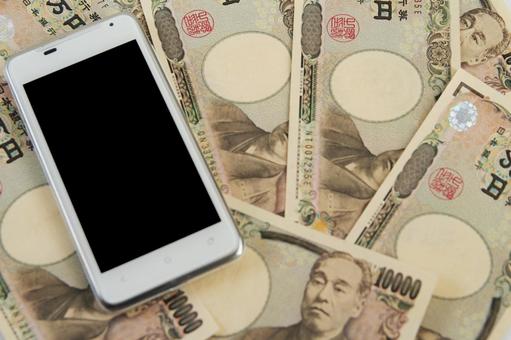 スマホと日本円の紙幣 スマホと日本円の紙幣の写真