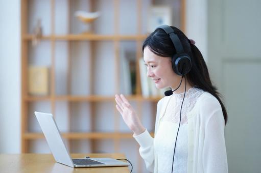 パソコンに向かい手を振る女性 女性,ノートパソコン,笑顔の写真素材