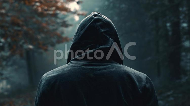フードをかぶり道を歩く男性の後ろ姿 フード,パーカー,匿名の写真素材