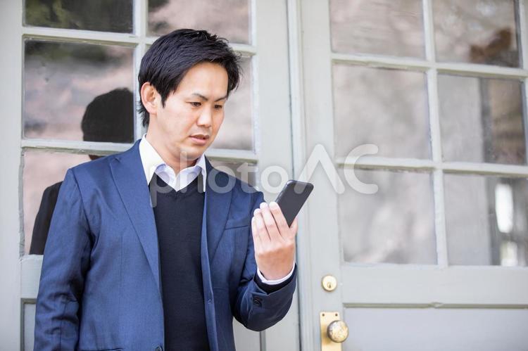 カジュアルビジネスの会社員 スマホ,困る,驚くの写真素材