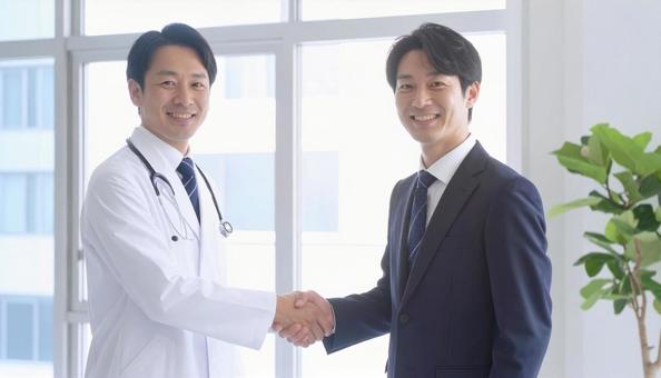 握手するビジネスパーソンと医者 握手するビジネスパーソンと医者の写真