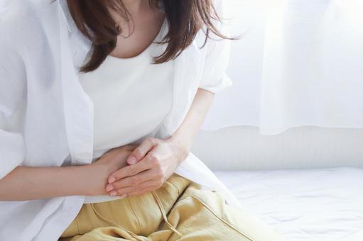 お腹を抑える女性 腹痛イメージ お腹を抑える女性 腹痛イメージの写真