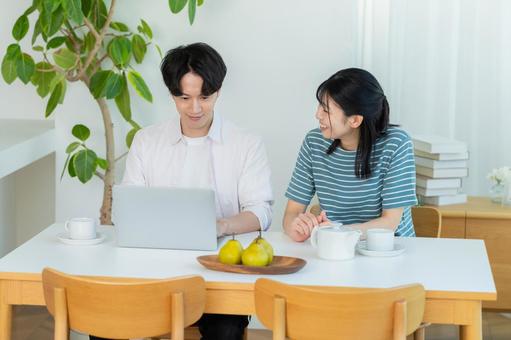 パソコンを見るカップル ノートパソコン,笑顔,カップルの写真素材