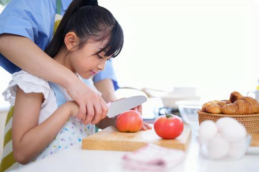 親子でトマトを切るキッチンでのひととき 女の子,トマト,野菜の写真素材