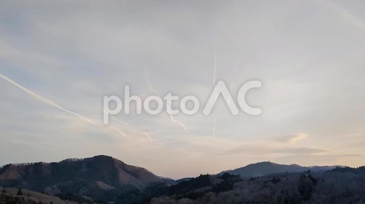 夕日と飛行機雲の風景 飛行機雲,夕日,夕景の写真素材