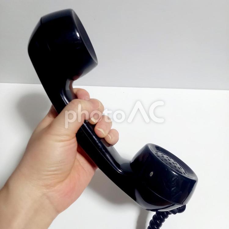 ダイヤル式黒電話の送受話器を持った状態1 黒電話,アナログ,ダイヤルの写真素材