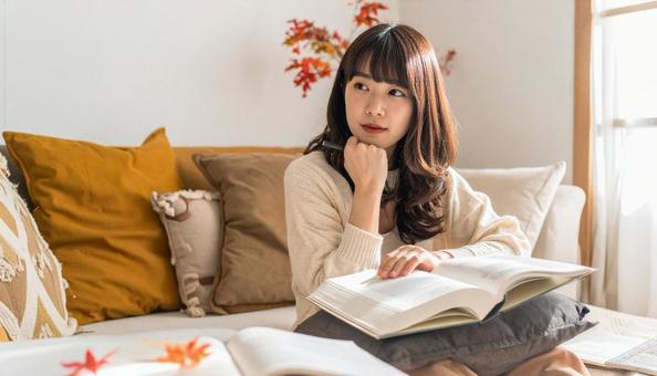 秋、部屋の中で勉強する日本人女性の写真