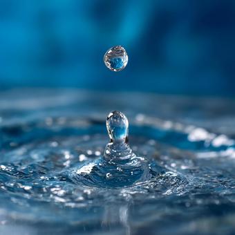 鮮やかな青い水に落ちる水滴の瞬間 鮮やかな青い水に落ちる水滴の瞬間の写真