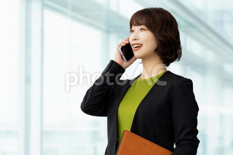 スマホで話す笑顔のビジネスウーマン 女性,ビジネス,スマホの写真素材