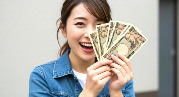 大金を手にして喜ぶ女性 大金を手にして喜ぶ女性の写真