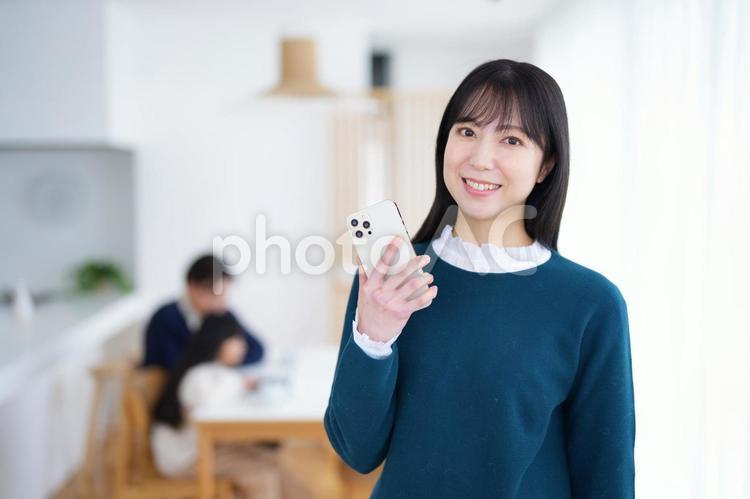 カメラ目線で携帯を持っている女性 家族,女性,女の子の写真素材