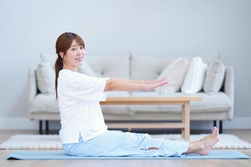 座って両手足を伸ばすカメラ目線の女性 女性,笑顔,まっすぐの写真素材