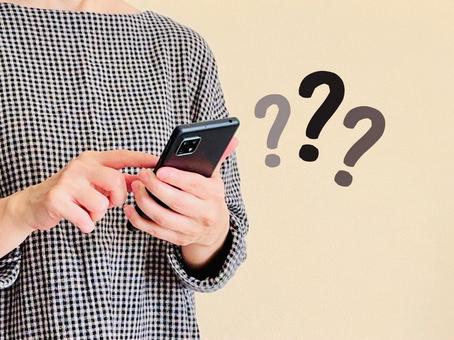 スマホを操作する女性＋クエスチョンマーク 女性,スマホ,クエスチョンの写真素材
