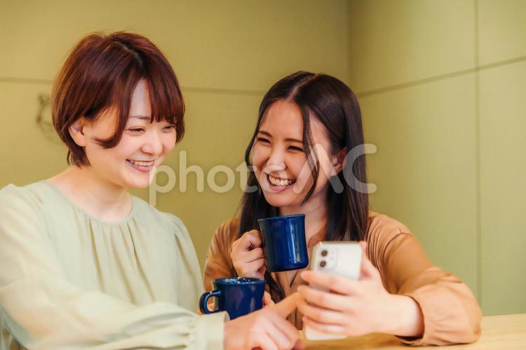 女友達とスマホを見て盛り上がる スマホ,スマートフォン,アプリの写真素材