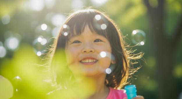 シャボン玉で遊ぶ笑顔の女の子 シャボン玉で遊ぶ笑顔の女の子の写真