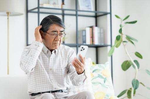 スマホで悩むシニアの男性 スマホで悩むシニアの男性 スマホ,悩む,シニアの写真素材