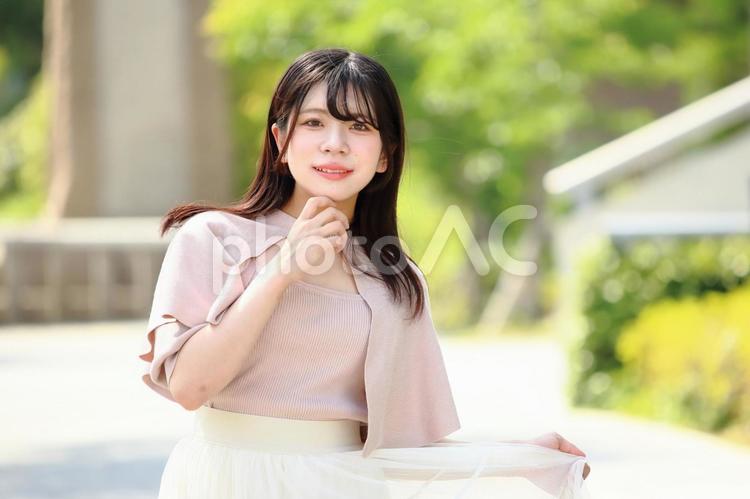 緑道でポーズをとる笑顔の女性 女性,20代,若いの写真素材