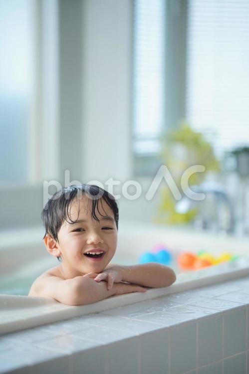 縁に顎を乗せてお風呂に入っている男の子 お風呂,男の子,子どもの写真素材