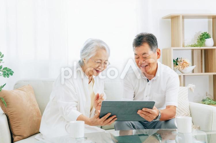 タブレットPCを見る高齢者夫婦（笑顔） 高齢者,タブレット,光テレビの写真素材
