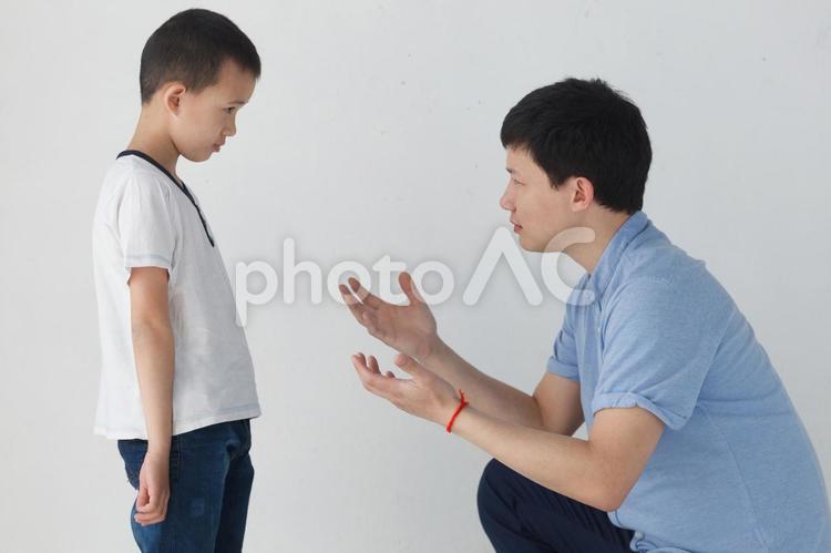 しゃがんで息子に話しかけるアジア人のお父さん1 アジア人,家族,お父さんの写真素材