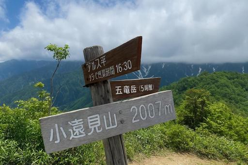小遠見山の山頂標識と北アルプスの風景 小遠見山の山頂標識と北アルプスの風景の写真