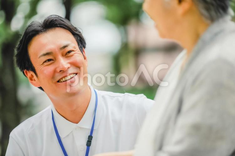 車椅子に乗った高齢者女性と男性スタッフ 介護士,理学療法士,作業療法士の写真素材