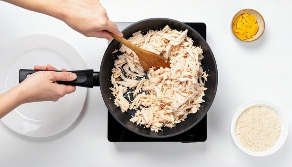 フライパンで鶏肉を炒める女性の手 フライパンで鶏肉を炒める女性の手の写真