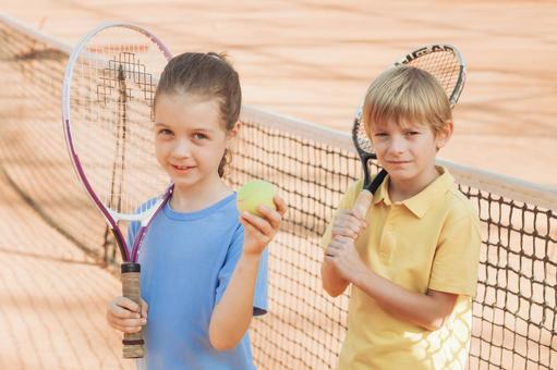 クレイコートで挨拶をする二人の子供 男の子,女の子,外国人の写真素材