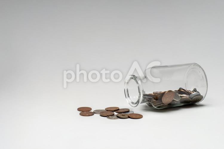 瓶からこぼれ出した少額のお金 コイン,お金,硬貨の写真素材