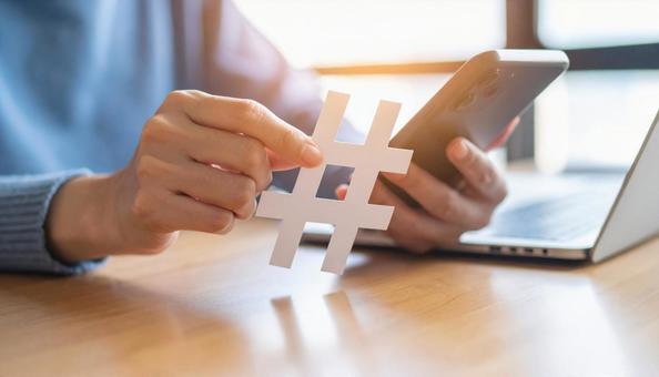 ハッシュタグを指でつまむ日本人女性の手の写真