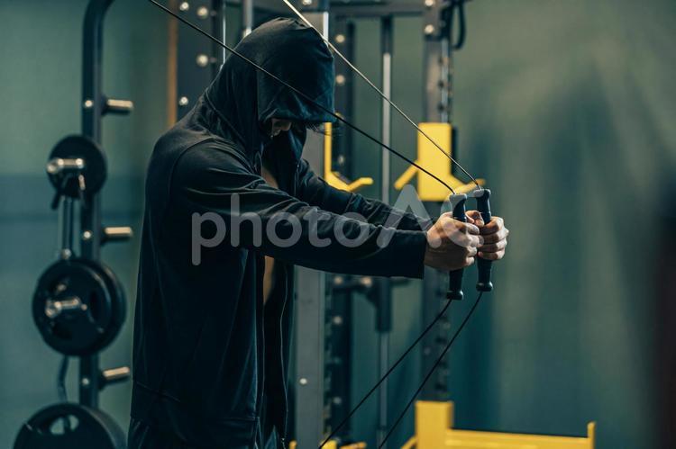 スポーツジムでケーブルマシンを使う男性 ケーブルマシン,スポーツジム,ワークアウトの写真素材