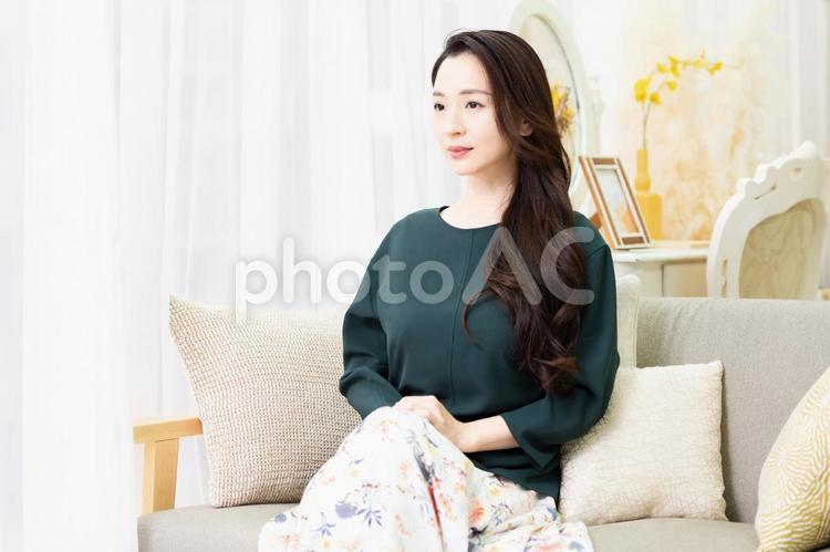 窓際のソファーに座る主婦 ソファー,窓,女性の写真素材